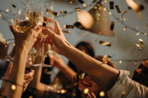 Guests with raised glasses and toasting with champagne at a wedding.